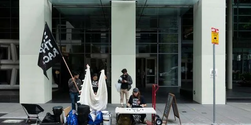 Protesters with flags and a literature table outside an AI company office